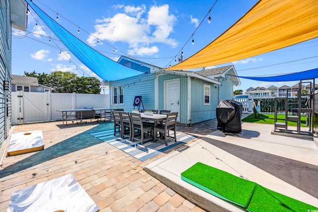 view of patio featuring a fenced backyard, a gate, outdoor dining space, and area for grilling