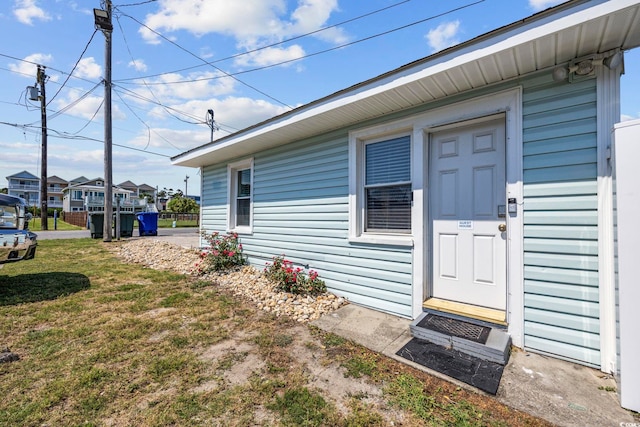 view of exterior entry with a yard