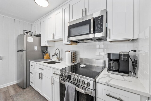 kitchen with a sink, appliances with stainless steel finishes, and white cabinets