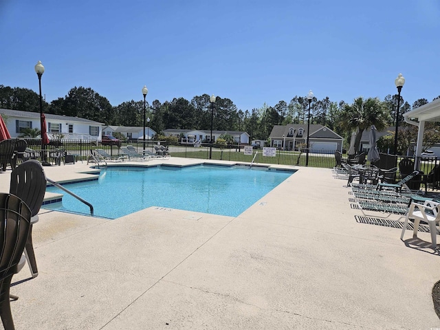 community pool featuring a patio and fence