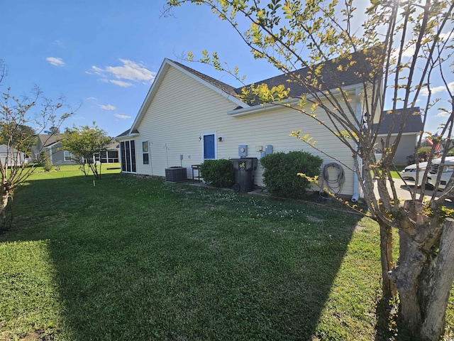 view of side of home with a lawn and central AC unit