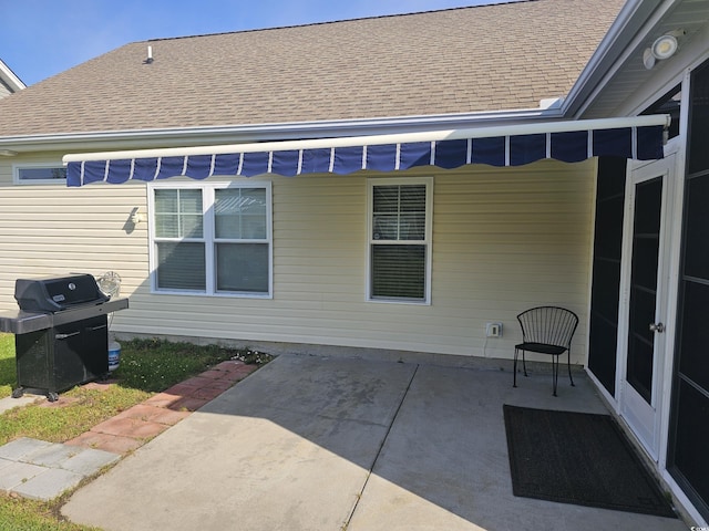 exterior space featuring roof with shingles and a patio area