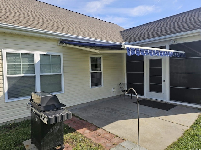 back of house featuring a patio and roof with shingles