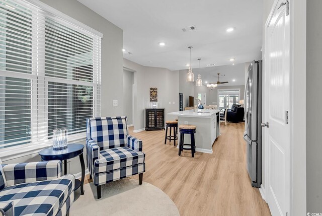 living room with baseboards, recessed lighting, visible vents, and light wood-style flooring