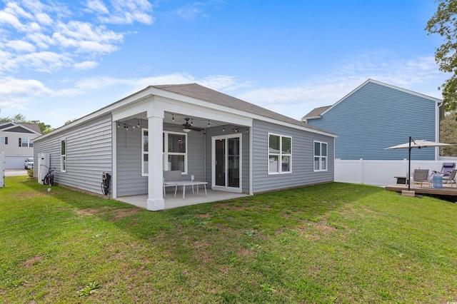 back of property featuring a lawn, fence, ceiling fan, and a patio area