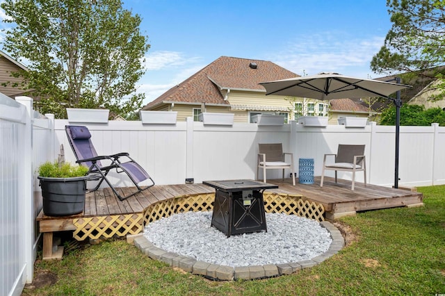 exterior space with fence, a wooden deck, and an outdoor fire pit