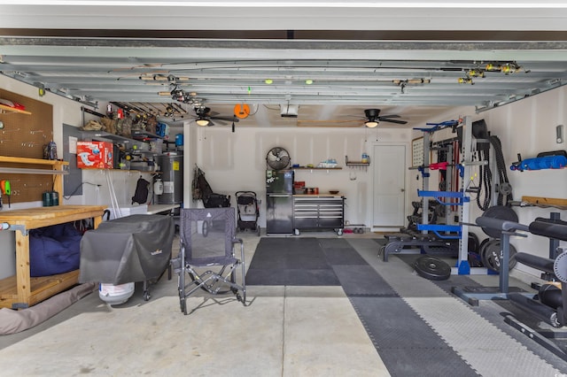 garage with freestanding refrigerator, ceiling fan, a garage door opener, a workshop area, and water heater