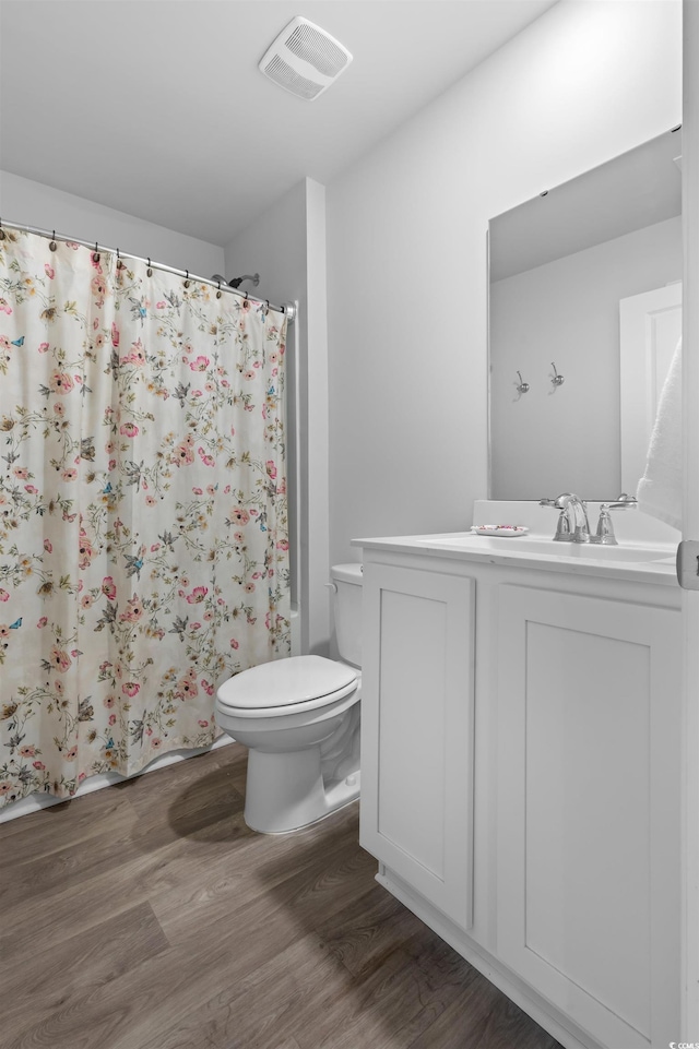full bathroom featuring visible vents, vanity, wood finished floors, toilet, and a shower with curtain