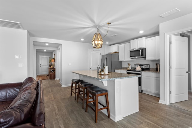 kitchen featuring visible vents, wood finished floors, open floor plan, recessed lighting, and stainless steel appliances