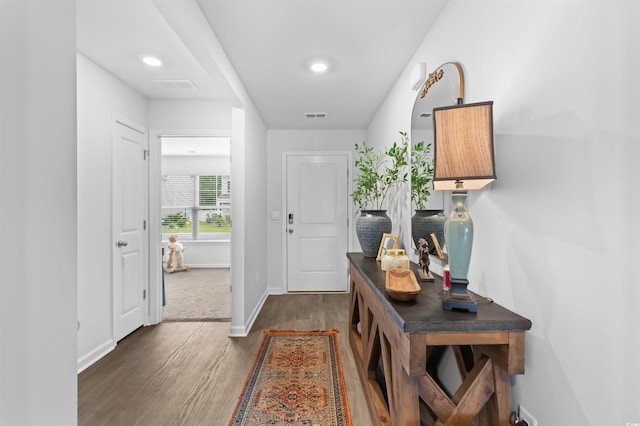 interior space featuring baseboards, wood finished floors, and visible vents