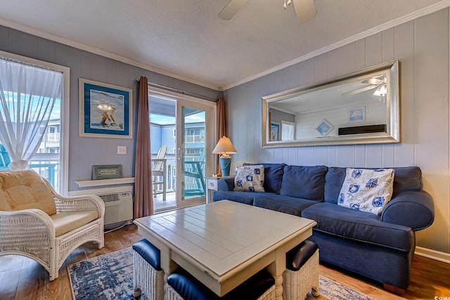 living room featuring ornamental molding, a ceiling fan, wood finished floors, and a wall mounted air conditioner