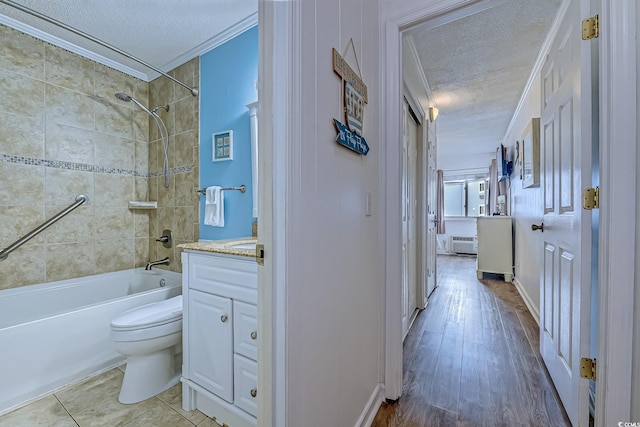 bathroom featuring washtub / shower combination, vanity, a textured ceiling, toilet, and wood finished floors