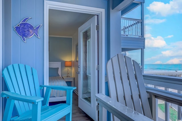 balcony featuring a water view and a beach view