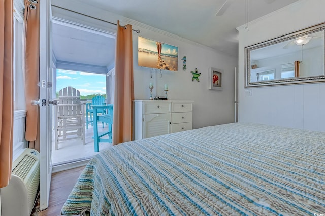 bedroom featuring crown molding, a ceiling fan, wood finished floors, access to exterior, and a wall mounted air conditioner