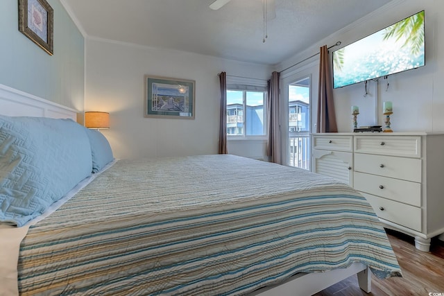 bedroom featuring crown molding, a ceiling fan, and wood finished floors