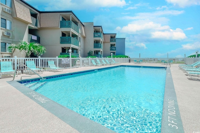 pool with a patio and fence