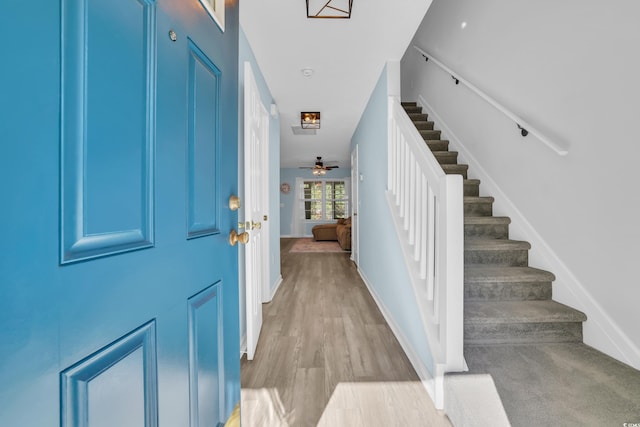 entrance foyer featuring stairway, wood finished floors, a ceiling fan, and baseboards