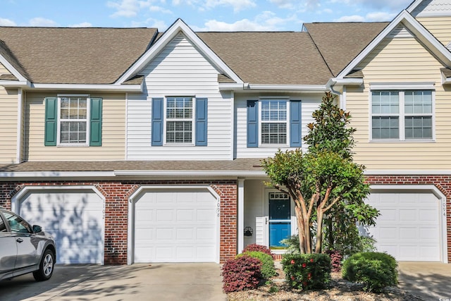 multi unit property featuring driveway and brick siding