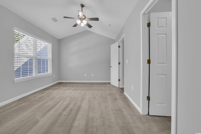 unfurnished bedroom with carpet flooring, visible vents, baseboards, vaulted ceiling, and a ceiling fan