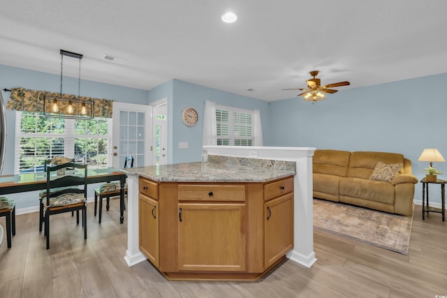 kitchen with pendant lighting, visible vents, ceiling fan, and light wood-style flooring