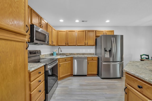 kitchen with a sink, visible vents, stainless steel appliances, light wood-type flooring, and recessed lighting