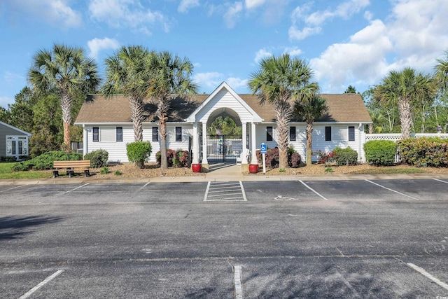 view of building exterior featuring fence and uncovered parking