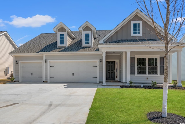 1513 Anne St, North Myrtle Beach, SC 29582 - view of front facade featuring an attached garage, board and batten siding, a shingled roof, driveway, and a front lawn