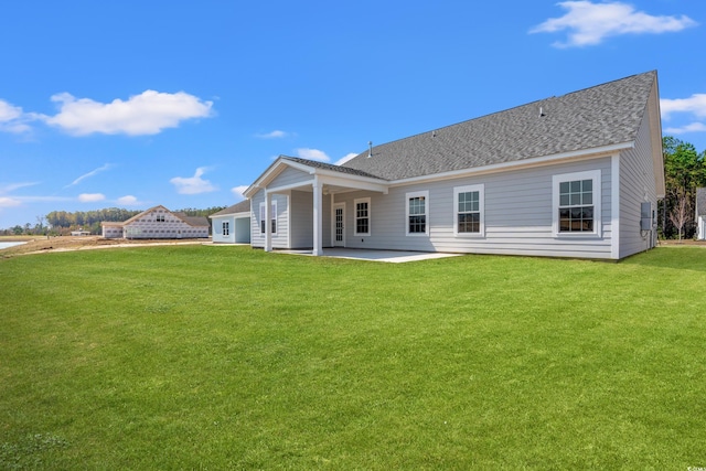 1513 Anne St, North Myrtle Beach, SC 29582 - back of house featuring a patio, a lawn, and roof with shingles