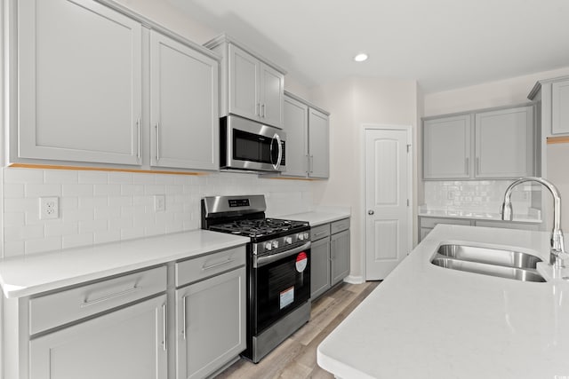 1513 Anne St, North Myrtle Beach, SC 29582 - kitchen featuring appliances with stainless steel finishes, gray cabinetry, light wood-style flooring, light countertops, and recessed lighting