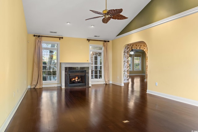 unfurnished living room featuring visible vents, arched walkways, ceiling fan, a fireplace, and wood finished floors
