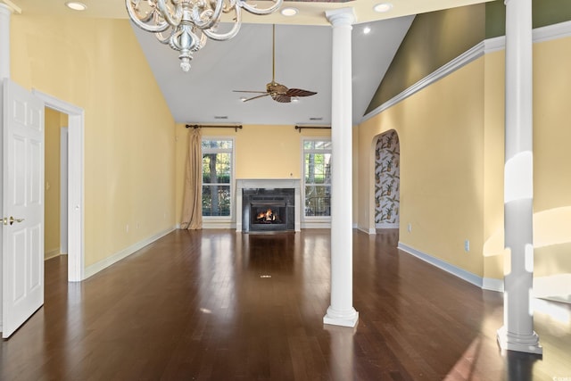 808 E Coast Ln, North Myrtle Beach, SC 29582 - unfurnished living room featuring a chandelier, wood finished floors, a fireplace with flush hearth, ornate columns, and high vaulted ceiling