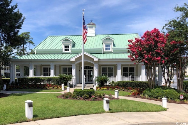 808 E Coast Ln, North Myrtle Beach, SC 29582 - view of front of home featuring a porch, a standing seam roof, a front lawn, and a metal roof