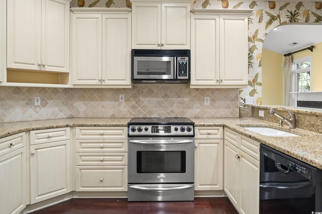 808 E Coast Ln, North Myrtle Beach, SC 29582 - kitchen with stainless steel appliances, light stone counters, dark wood-style floors, and tasteful backsplash