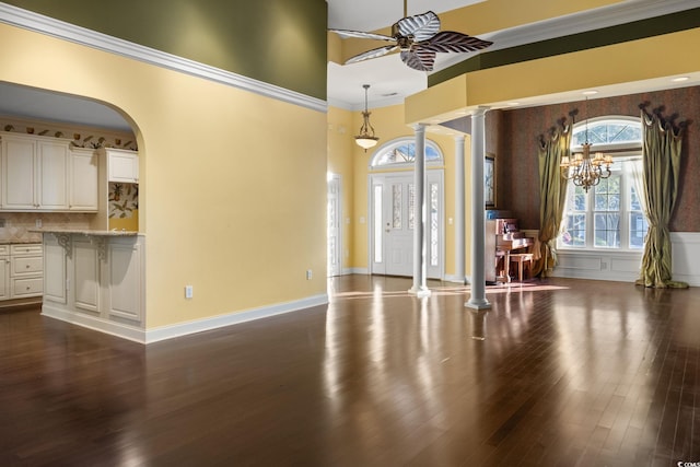 808 E Coast Ln, North Myrtle Beach, SC 29582 - unfurnished living room with decorative columns, ceiling fan, arched walkways, dark wood-type flooring, and a high ceiling