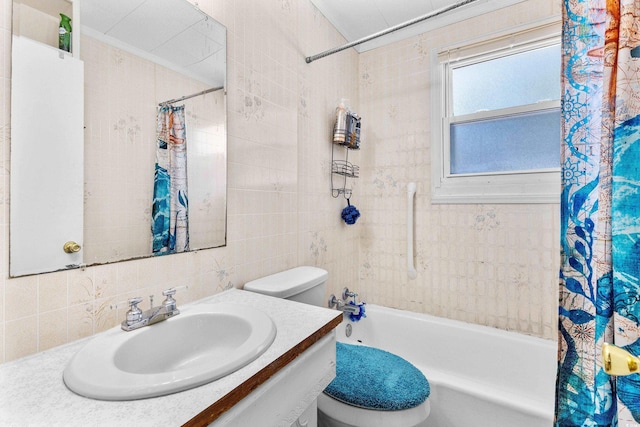 full bath featuring vanity, toilet, tile walls, and shower / tub combo with curtain