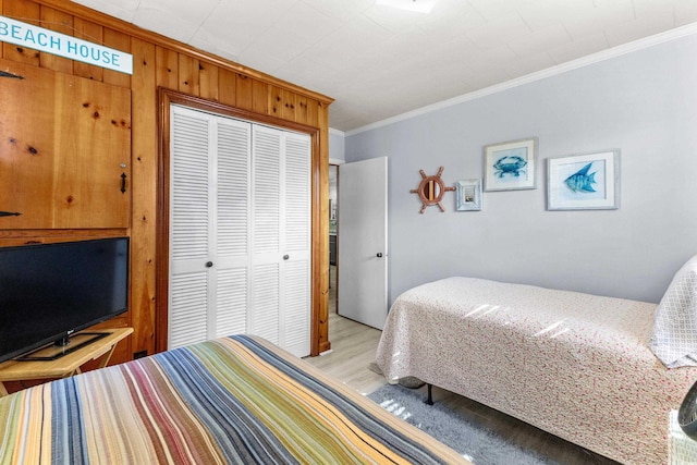 bedroom featuring crown molding, a closet, and light wood finished floors