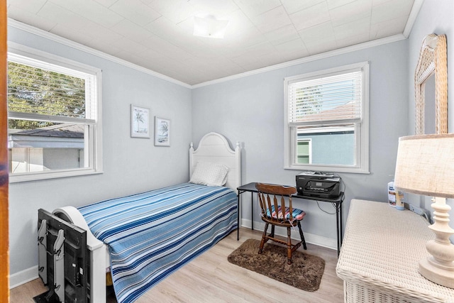 bedroom featuring baseboards, ornamental molding, and wood finished floors