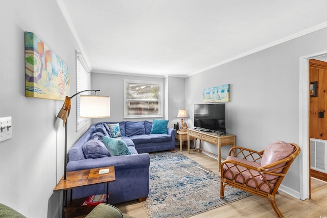 living area with visible vents, light wood-style flooring, and crown molding