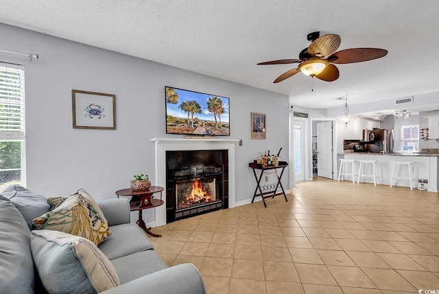 157 Egret Run Ln Unit 514, Pawleys Island, SC 29585 - living area with a ceiling fan, plenty of natural light, a fireplace, light tile patterned flooring, and a textured ceiling