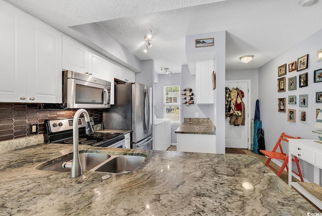 157 Egret Run Ln Unit 514, Pawleys Island, SC 29585 - kitchen with washer and dryer, appliances with stainless steel finishes, tasteful backsplash, stone countertops, and a textured ceiling