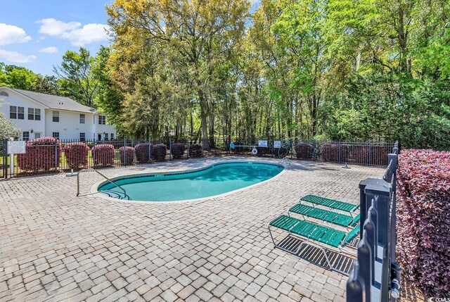 157 Egret Run Ln Unit 514, Pawleys Island, SC 29585 - community pool featuring a patio area and view of wooded area