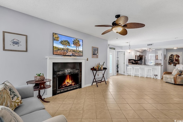 157 Egret Run Ln Unit 514, Pawleys Island, SC 29585 - living room with a fireplace, light tile patterned floors, a ceiling fan, and a textured ceiling