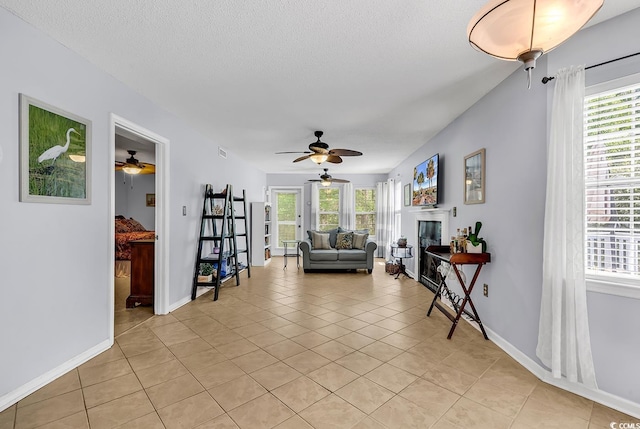 157 Egret Run Ln Unit 514, Pawleys Island, SC 29585 - living room with a ceiling fan, light tile patterned floors, a glass covered fireplace, and a textured ceiling