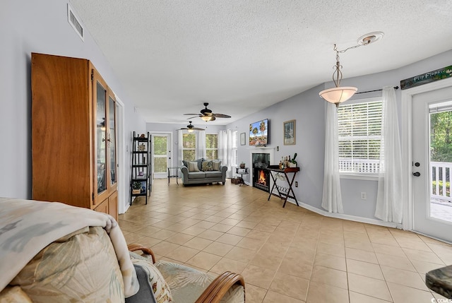 157 Egret Run Ln Unit 514, Pawleys Island, SC 29585 - living room with light tile patterned flooring, a textured ceiling, a glass covered fireplace, and ceiling fan