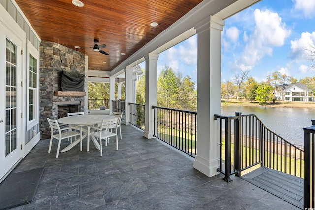 1006 Surf Pointe Dr, North Myrtle Beach, SC 29582 - view of patio / terrace with an outdoor stone fireplace, a water view, ceiling fan, and outdoor dining area