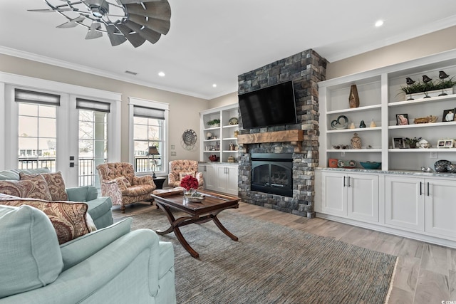 1006 Surf Pointe Dr, North Myrtle Beach, SC 29582 - living room with ornamental molding, a ceiling fan, a stone fireplace, light wood-type flooring, and recessed lighting