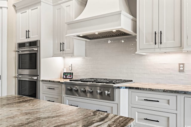 1006 Surf Pointe Dr, North Myrtle Beach, SC 29582 - kitchen featuring custom exhaust hood, stainless steel appliances, backsplash, and light stone countertops
