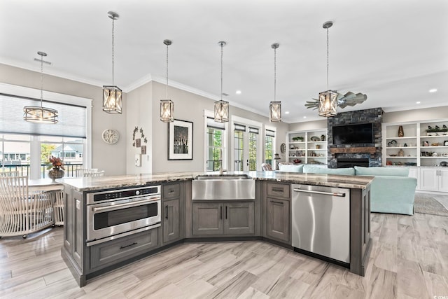 1006 Surf Pointe Dr, North Myrtle Beach, SC 29582 - kitchen with stainless steel appliances, a fireplace, light stone countertops, a ceiling fan, and a sink