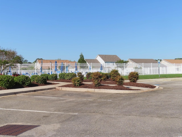 uncovered parking lot featuring fence