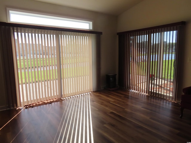 819 Brookline Dr, Myrtle Beach, SC 29579 - empty room with a wood stove, healthy amount of natural light, wood finished floors, and lofted ceiling